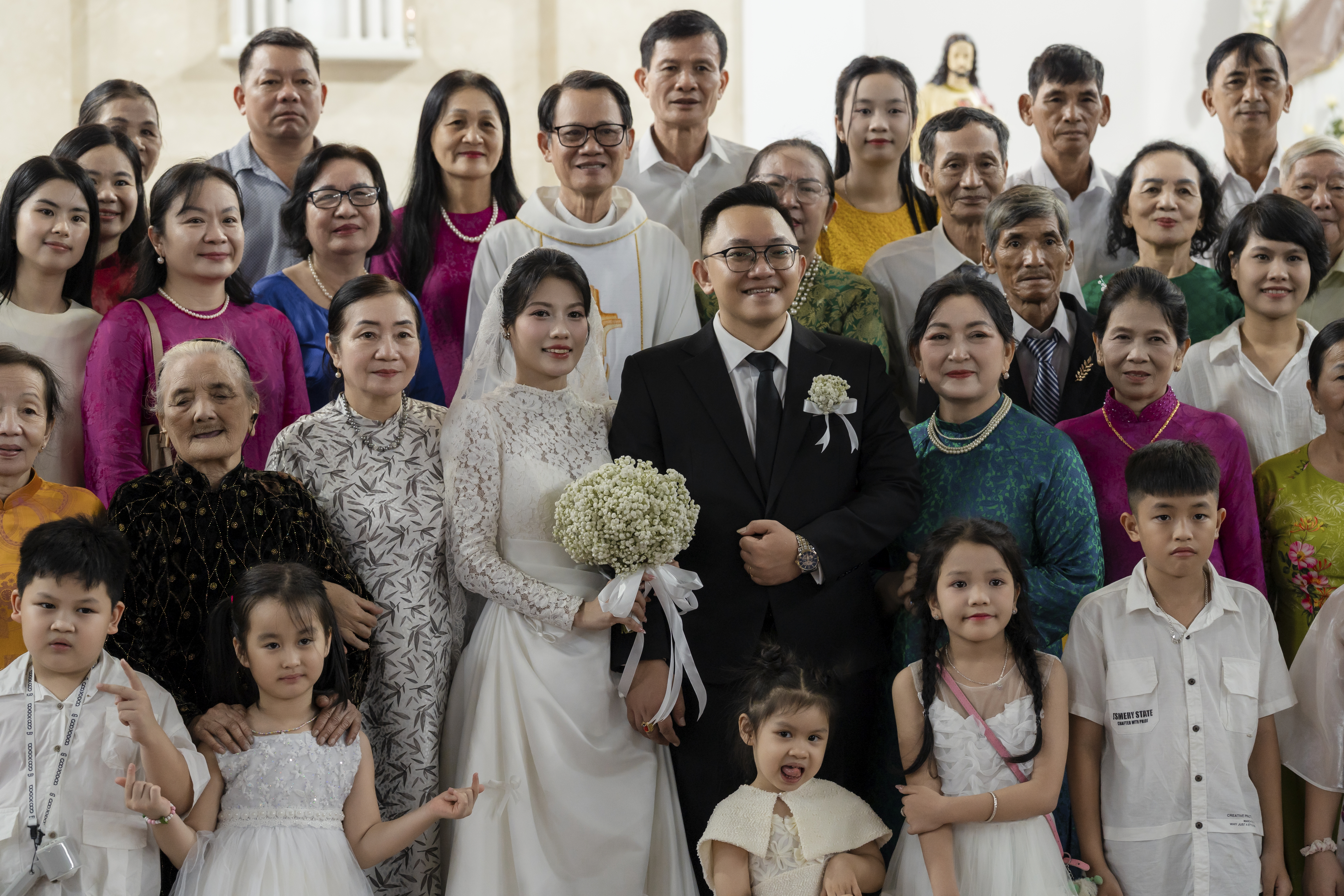 Bức ảnh kỷ niệm đầm ấm của Trúc & Văn cùng Linh mục và hai họ sau Thánh lễ